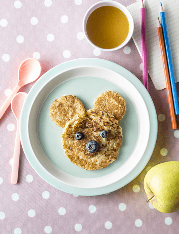Pancackes en forme d'ourson dans une assiette pour enfant avec des myrtilles