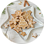 Petits biscuits sablés en forme de sapin dans une assiette en forme d'étoile blanche et dorée