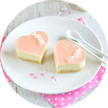 Deux gâteau en cœur rose sur une assiette avec deux petites cuillères