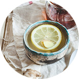 tasse de thé et tranche de citron sur une nappe blanche