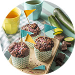trois muffins au chocolat sur une table décorée pour un anniversaire