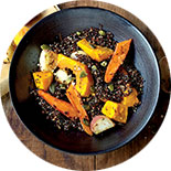 Assiette noire vue de haut contenant du quinoa et légumes