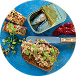 couteau sur des tartines de rillettes et boîte de sardines sur un fond bleu