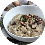 Assiette de risotto aux champignons posée sur une nappe grise